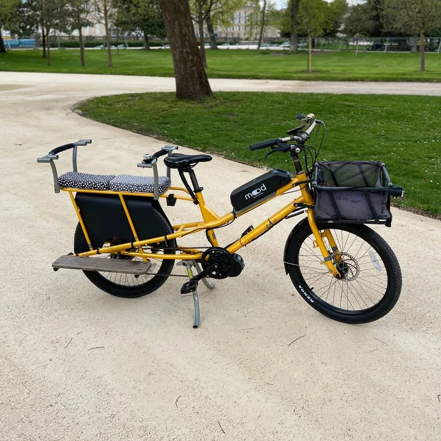 Cargo longtail jaune Yuba électrifié par Mood, avec assises enfants et panier avant